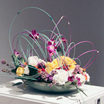 A floral design in the 2012 Petals & Paintings exhibition at Krannert Art Museum reflects the colors and shape of a glass sculpture. A floral arrangement by local florist Rick Orr for the 2013 Petals & Paintings exhibition at Krannert Art Museum was inspired by a painting of an ocean. Photos courtesy Krannert Art Museum