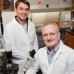 Professor of pathobiology Daniel Rock (seated) and postdoctoral researcher Diego Diel are part of a team that will work to create a one-dose vaccine for livestock that will prevent multiple diseases for an extended period of time.