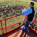 Band director Barry Houser supervises the Marching Illini from a rented scissor lift overlooking the field behind the Krannert Art Museum.