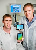 Paul Hergenrother, left, professor of chemistry, and Brian Cunningham, professor of electrical and computer engineering, hold biosensors they've developed that are capable of detecting protein-DNA interactions.