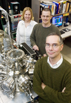 Martin Gruebele, front, a professor of chemistry, physics and biophysics, stands next to the device he and Joshua Ballard, postdoctoral research associate, and graduate student Erin Carmichael use for laser-assisted scanning tunneling microscopy.