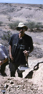 Anthropologist Stanley Ambrose collects fossil soils, armed with his trowel, hammer and folding army shovel, from the area where the new Ardipithecus remains were found.