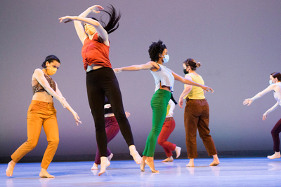 Photo of a group of dancers moving on a stage.
