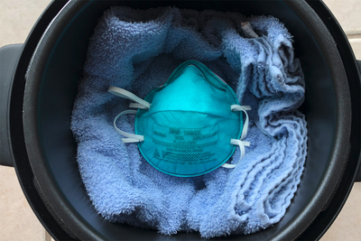 An N95 mask in a multicooker with a towel.