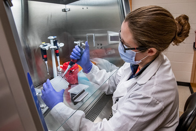 A female lab technician analyzes a saliva sample