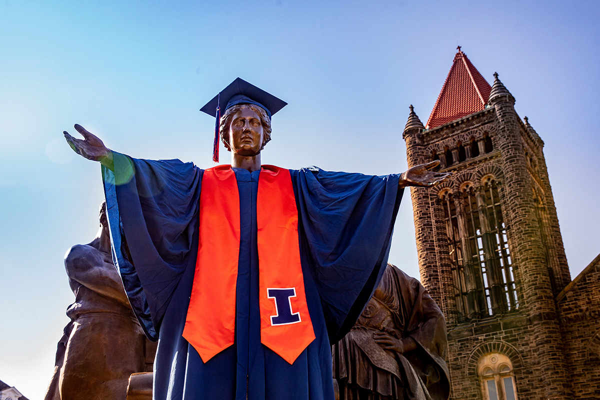 Dressed in graduation regalia, the Alma Mater statue welcomes people to campus