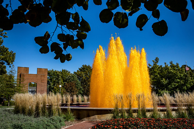 Bright orange water sprays into a blue sky during the Homecoming kickoff celebration.