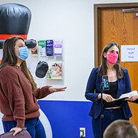 Whitney Greger, left, and Jessica Brinkworth, center, critique the student projects and discuss ways to reach targeted age groups.