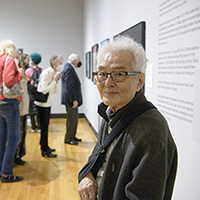 Photo of Shozo Sato standing in a gallery at Krannert Art Museum.