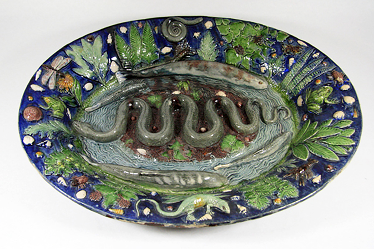 Photo of a platter with a cast of a snake in its center and casts of fish and frogs around the edges.