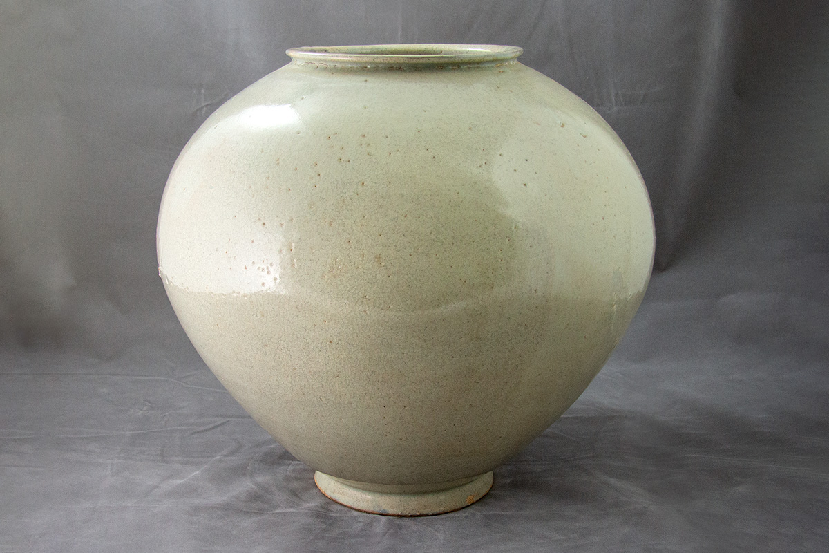 Photo of a large, spherical Korean moon jar with a crackled white glaze.