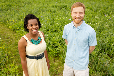 Researchers stand in a natural area with prairie plants in the background.
