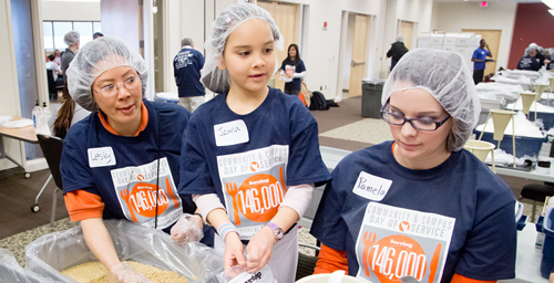 Feeding the hungry Volunteers packaged more than 81,000 meals for the Eastern Illinois Foodbank on April 20 as part of the Day of Service, which sought to encourage people to volunteer as well as provide meals for the hungry in our community. Among those volunteering for the food packaging project were (from left) Lesley Lee, a U. of I. library specialist; her daughter, Jenna Purnell, age 7; and Parkland College student Pamela Roper.  Click photo to enlarge