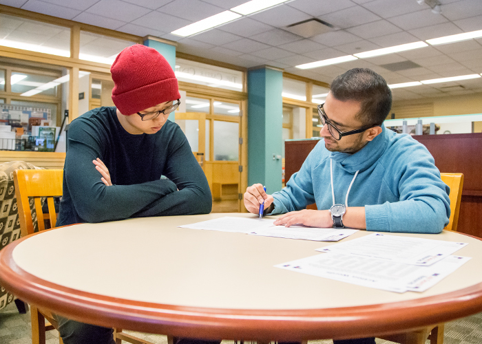 Yanchen Shi (left), a senior in bioengineering from Dunlap, Illinois, gets his resume reviewed at The Career Center by Rameez Siddiqui, a student paraprofessional there.