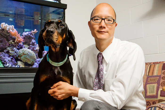 University of Illinois veterinary clinical medicine professor Timothy Fan, pictured here with his dog, Ember, describes the advantages of testing potential cancer therapies on pet dogs with spontaneously occurring cancers.
