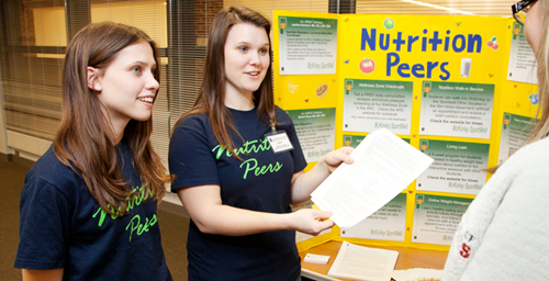 Seniors Liz Reynolds, left, and Colleen Koehler staff the Nutrition Peers booth at the Runners Clinic in the Wellness Center at the Activities and Recreation Center. Their goal is to help studets prepare for the Illinois Marathon.  '
