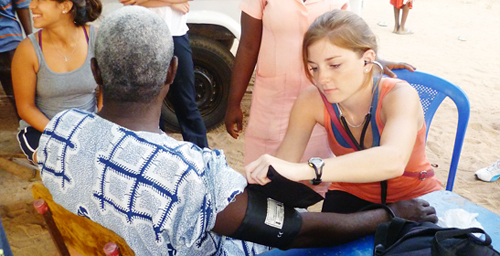 Cristi Wales, a senior in kinesiology from Glen Elllyn, Ill., take blood pressure in the village of Ghada, Ghanam during the Frontiers International Health Society trip over winter break.
