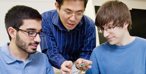 Industrial design professor Cliff Shin, center, assists graduate student Ehsan Noursalehi, left, of Naperville, Ill., and engineering student Kevin Verre, of Niles, Ill., during a meeting of the "A New Life for Laptops" research group.