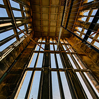 Photo looking upward at the Altgeld Bell tower with tall windows on all sides and cables going up to the ceiling.