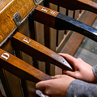 Close-up photo of a pair of hands on the levers of the chimes keyboard.