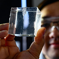 Zhang holds up a tiny cube of the gelatin