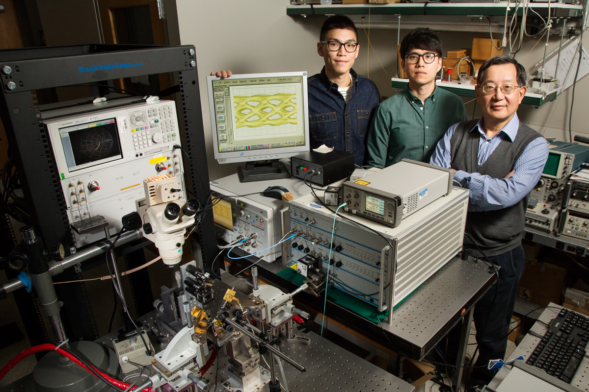 University of Illinois engineers developed fiber-optic technology that can transmit data at a blazing-fast 57 gigabits per second, without errors. Pictured are graduate students Curtis Wang and Michael Liu with professor Milton Feng.