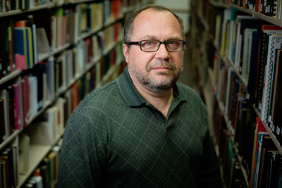 Jan Adamczyk, a senior library specialist, in between rows of books.