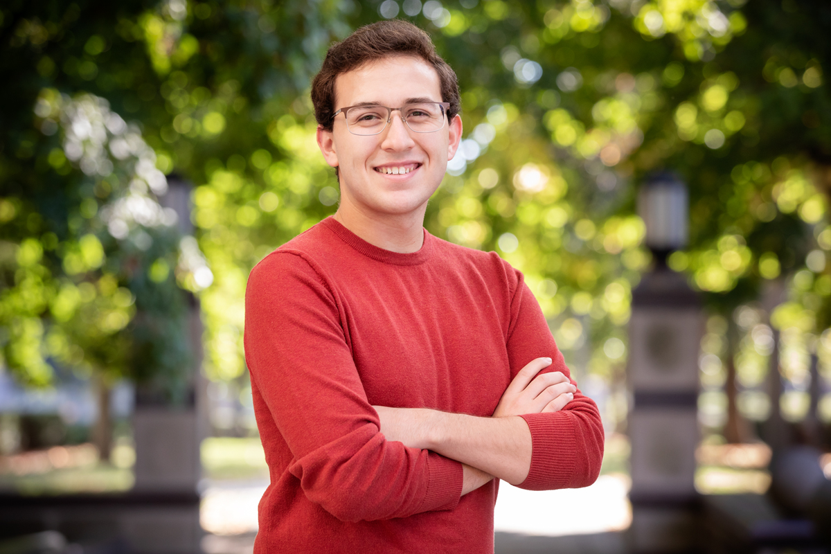 Photo of graduate student Ben David standing outdoors with his arms crossed.