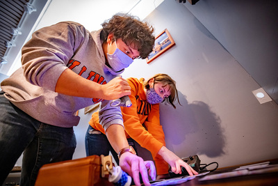 students Duncan McMillan and Mary Kate Baughman work on solving a puzzle in an escape room.