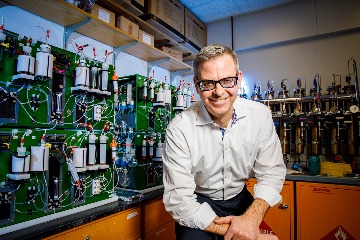 Dr. Martin Burke sits in front of the automated molecule-making machine he developed.