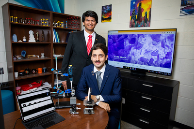 Professor Nishant Garg, standing, and graduate student Hossein Kabir, seated, in their laboratory