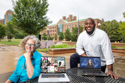 Bioengineering professor Jennifer Amos, seated, and postdoctoral research associate Gabriel Burks standing to her left with a laptop that displays public engagement coordinator Lara Hebert on the screen.