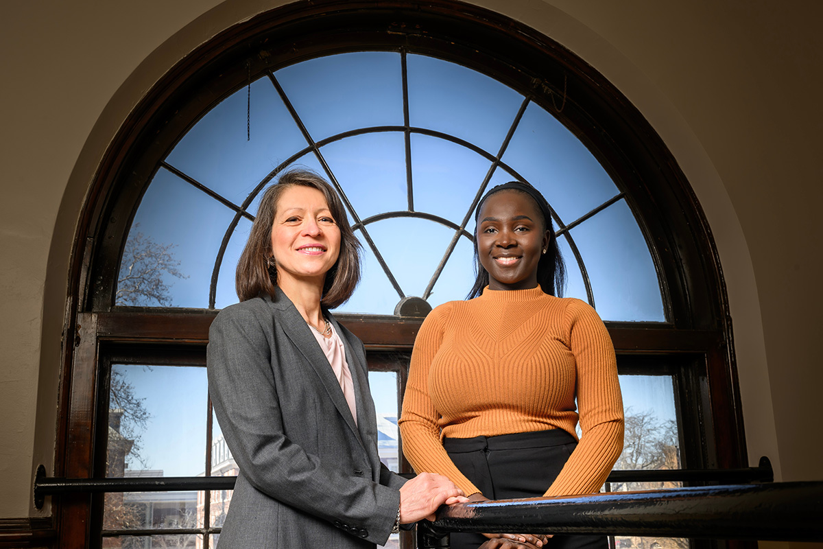 Photo of professor Sandraluz Lara-Cinisomo and graduate student Mary Ellen Mendy standing in front of an arched window