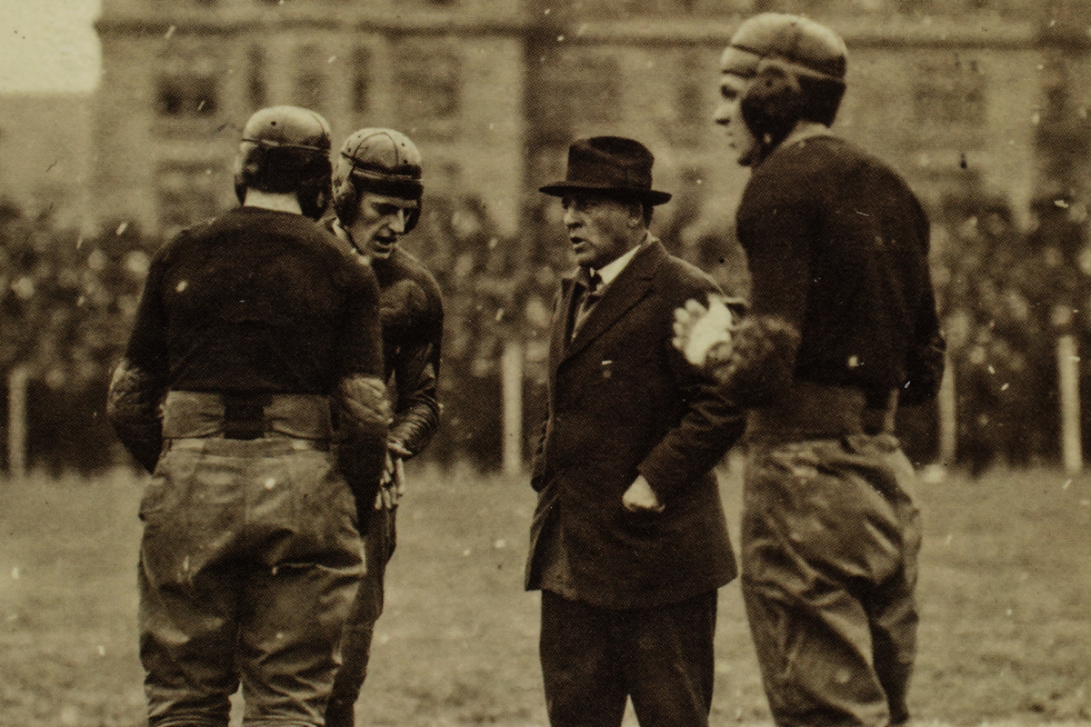 University of Chicago football coach Amos A. Stagg talks with three of his players during a game in 1916.