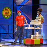 Image of Haven Crawley and Maya Prentiss onstage at a fast-food cash register.