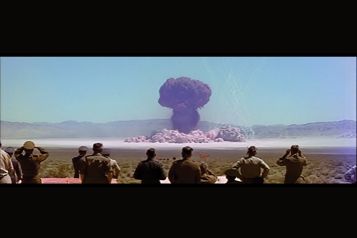 Observers look on during a Nevada nuclear test, one of many filmed by a secret Hollywood studio, its story chronicled by two Illinois professors.