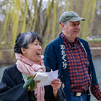 Photo of Jennifer Gunji-Ballsrud and Douglas Brooks laughing near a pond.