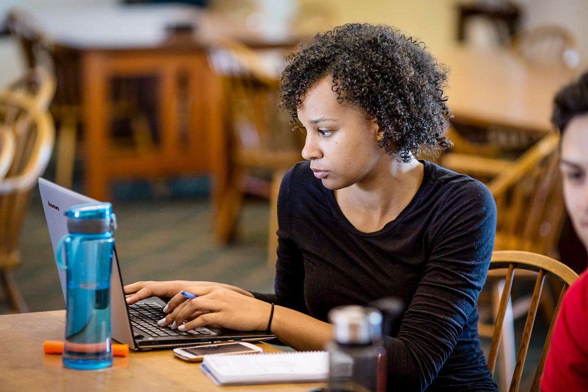 Photo of young woman at laptop computer in the library