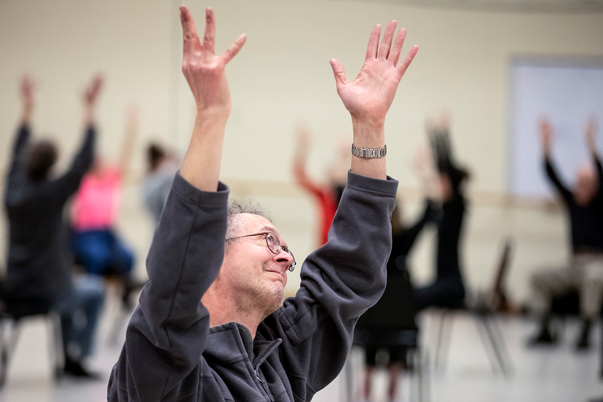 Gary Stitt, 61, stretches his arms to the sky as people gather for a Dance for People with Parkinson’s class at Krannert Center.