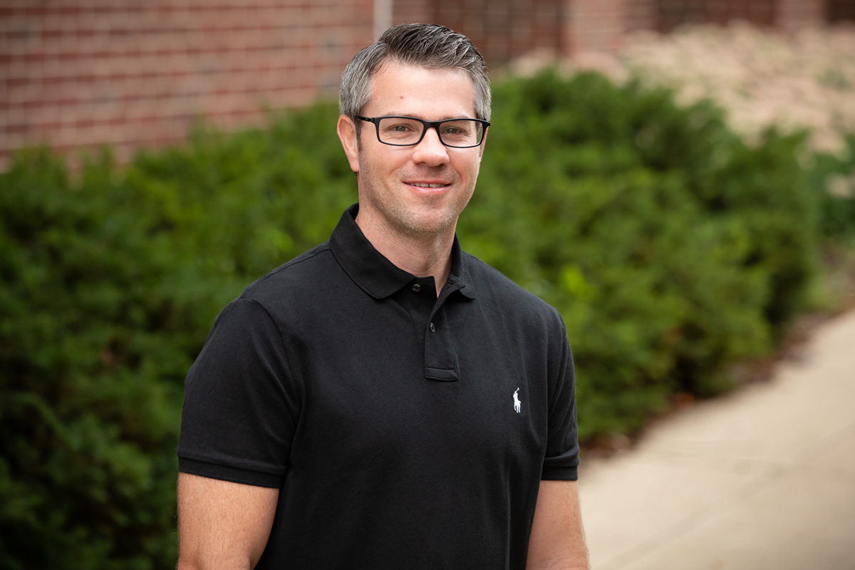 Kinesiology graduate student Brett Burrows standing outdoors wearing a dark shirt