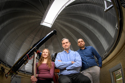 Undergraduate student Lily Kettler, left, professor Joaquin Viera and graduate student Kedar Phadke photographed inside an astronomical observatory