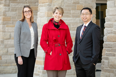 U. of I. social work professor Kevin Tan standing outside the Mahomet-Seymour School District building with director of instruction Nicole Rummel and superintendent Lindsey Hall, both of Mahomet-Seymour school district.