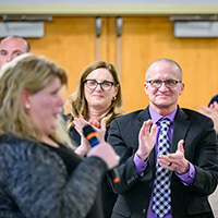 Former Police Training Institute director Michael Schlosser, center right, leads a standing ovation for exoneree Kristine Bunch. Schlosser worked with staff at the Illinois Innocence Project at the University of Illinois Springfield to bring the Wrongful Conviction Awareness and Avoidance class to the PTI in 2016.